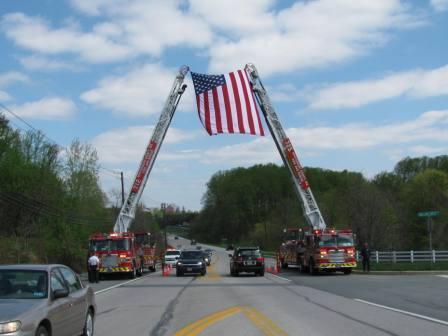 Truck 725 & Truck 712 cross aerials with the Flag of the United States of America to receive the funeral procession for the Line of Duty Death of MCPD Sergeant Hector Ayala.
<br><br>
End of Watch - 4 April 2010